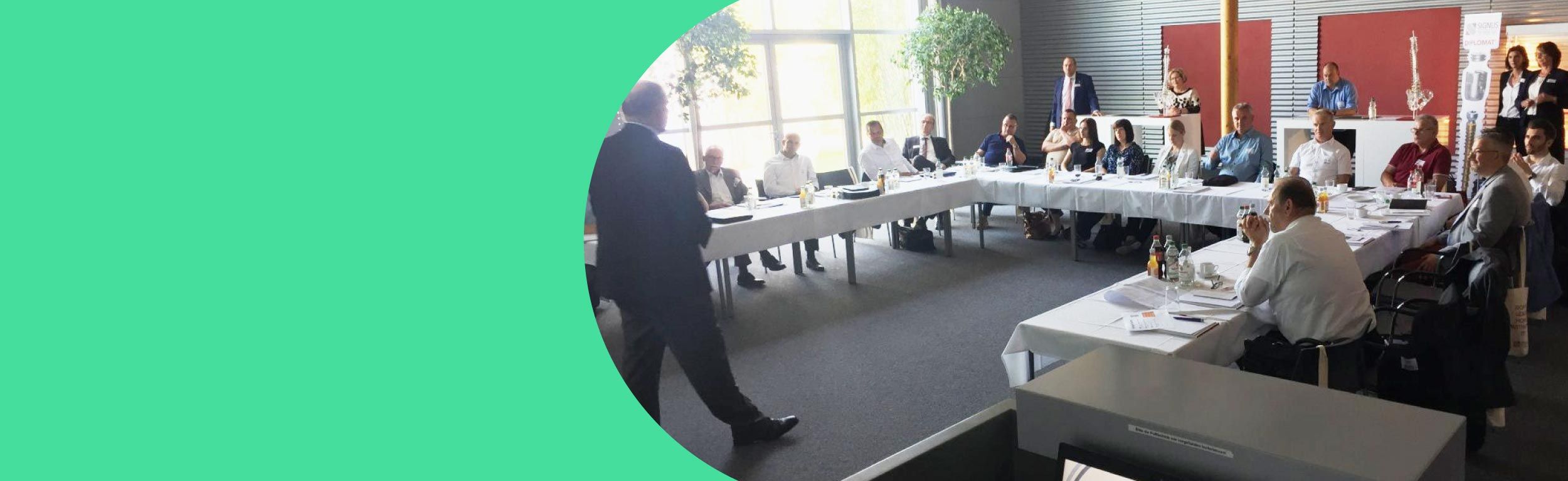 Mitglieder des femak e.V. sitzen während eines Regionaltreffens in einem Meeting.
