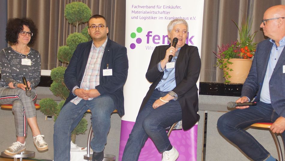 Personen sitzen auf einer Bühne und diskutieren über verschiedene Themen.
